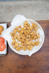 Freshly fried Louisiana oysters draining on a plate covered with a paper towel.