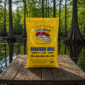 A 1 lb bag of yellow LA Crawfish Co. original seasoning on a wooden dock with a swamp in the background.