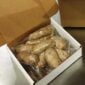 A cardboard box containing several vacuum-sealed Cajun Original Foods Pork Boudin Party Links.