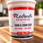 A container of frozen Rachael’s Crawfish Etouffee resting on a wooden surface.