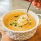 A spoonful of creamy Rachael’s Crab and Corn Soup topped with chopped green onions.