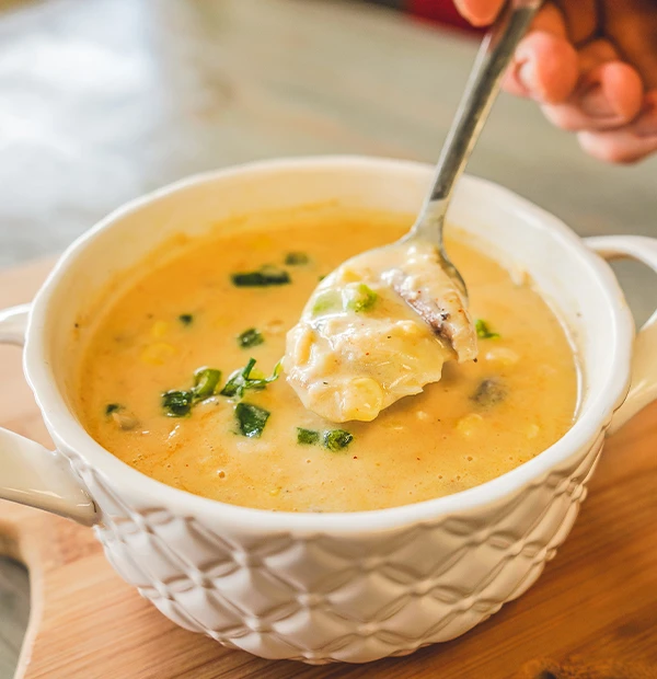 Rachael's Crab and Corn Soup A spoonful of creamy Rachael’s Crab and Corn Soup topped with chopped green onions.