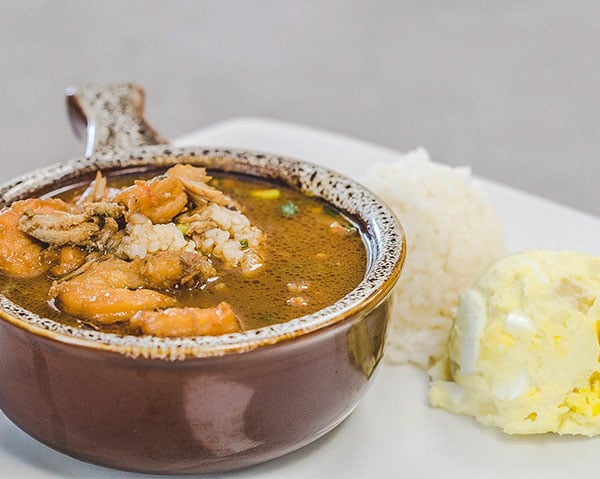 Rachael's Seafood Gumbo-2 A bowl of Rachael’s Seafood Gumbo with a scoop of white rice and a side of potato salad.