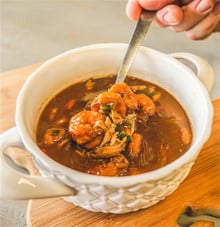 Rachael's Seafood Gumbo A spoon lifts shrimp and shredded meat from a bowl of Rachael’s Seafood Gumbo.