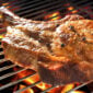 A Comeaux’s pork boudin stuffed pork chop, seasoned with cracked peppercorns, grilling over an open flame.