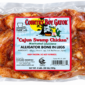 A vacuum-sealed package of two pounds of bone-in, marinated alligator legs with a product label.