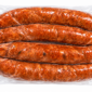 Four vacuum-sealed links of Comeaux’s Smoked Jalapeno Sausage with visible spice flecks.