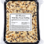 A 2 lb container of La Boucherie Wild Rice Pecan side dish in plastic wrap, showing a label with cooking instructions.