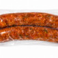 Two raw The Best Stop Jalapeno chicken sausage links with visible green peppers and spices, vacuum-sealed in plastic.