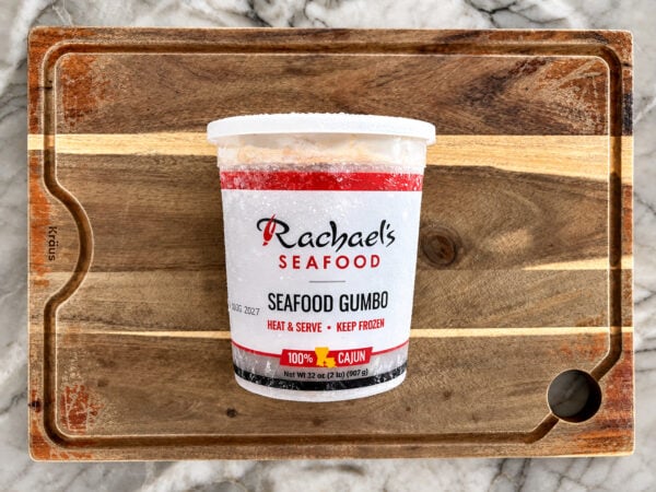 SeafoodGumbo A tub of Rachael’s Sampler frozen seafood gumbo on a wooden cutting board.
