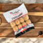 A package of Rachael’s Sampler frozen stuffed shrimp resting on a wooden cutting board.