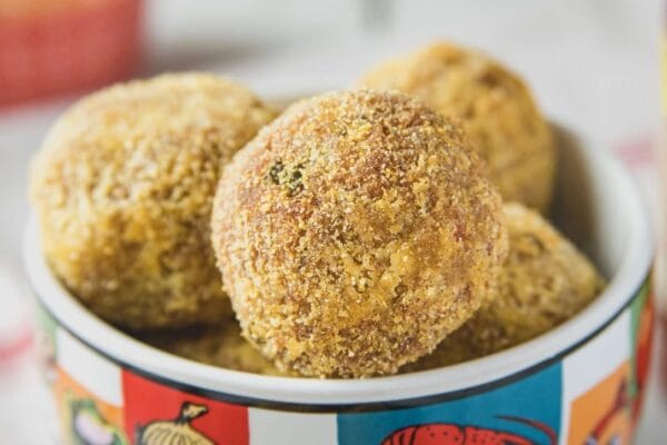 boudin_balls__80009.1744726274.1280.1280.jpg A vibrant dish displays golden-brown, breadcrumb-coated La Boucherie Boudin Balls ready to be served.
