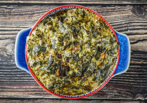 A La Boucherie 1 lb Creamed Spinach served in a round casserole dish, seen from above on a wooden surface.