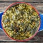 A La Boucherie 1 lb Creamed Spinach served in a round casserole dish, seen from above on a wooden surface.