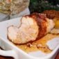 A sliced, roasted 5 lb LA Crawfish Co. Turducken Roll with stuffing in a white baking dish.