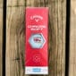 A box of LA Crawfish Co. golf balls featuring a crawfish logo sits on a wooden surface.