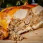 Sliced 15 lb La Boucherie Turducken on a board, served with Cajun meats and rice—perfect for Louisiana flavor lovers.