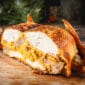 Sliced 15 lb La Boucherie Turducken reveals Cajun stuffing, a Louisiana classic, served on a wooden board.