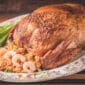 A 15 lb La Boucherie Turducken served on a platter with stuffing, shrimp, green onions, and Louisiana seafood flavors.