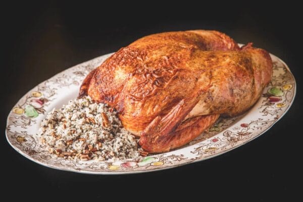 15lb_wild_rice__02380.1760541128.1280.1280.jpg A 15 lb La Boucherie Turducken on a platter, served with wild rice, pecans, and Cajun meats for a Southern feast.