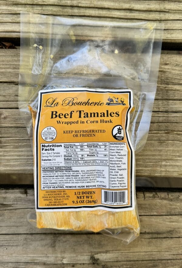 Vacuum-sealed La Boucherie Beef Tamales rest on wooden planks, with nutrition facts visible on the package.