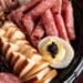 Rolled salami, sliced smoked cheese, and a deviled egg with spicy Cajun caviar on a premium Cajun meats platter.