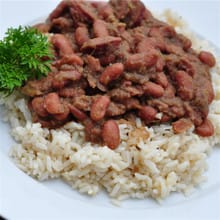 LA Crawfish Co Red Beans & Andouille served over white rice, topped with parsley for an authentic Cajun flavor.