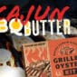 Close-up of a Bayou Carlin Oyster Combo box with flames, oysters, and Louisiana seafood theme. Text: “Bayou Carlin Oyster Combo.”.